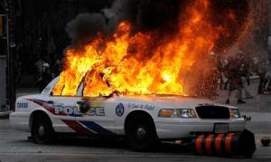 A police car set on fire by anarchist demonstrators burns in the midst of protests during the G20 summit in downtown Toronto